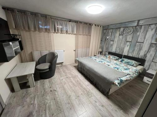 a bedroom with a bed and a desk and a chair at Privat FoRest in Liptovský Mikuláš