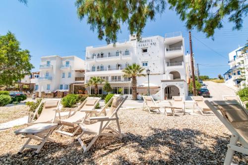 un grupo de sillas frente a un edificio en Agali bay hotel, en Tinos