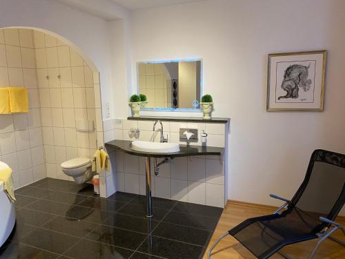 a bathroom with a sink and a toilet and a mirror at Schlossschänke Friedenfels in Friedenfels
