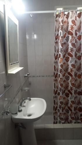a bathroom with a sink and a shower curtain at Casa Familiar in Mar del Plata
