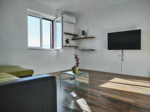 a living room with a couch and a tv on a wall at Viridis in Rijeka