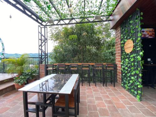 d'une terrasse avec une table, des chaises et un mur en briques. dans l'établissement Hotel, Restaurante y Bar Sofmel, à Copan Ruinas