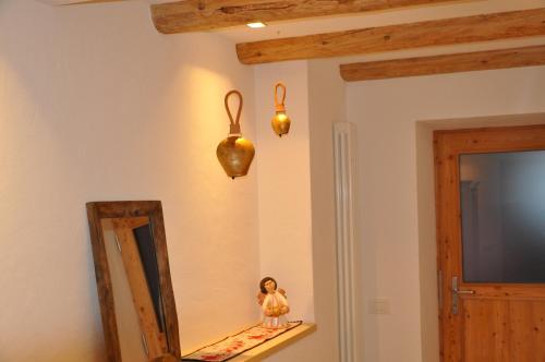 a mirror and a doll on a shelf in a room at Cèsa Sès da mont in Livinallongo del Col di Lana