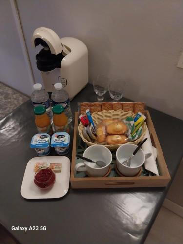 una mesa con una bandeja de comida y una cesta de comida en Le 18 by Benson en Bollène