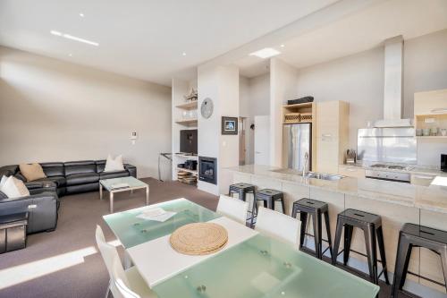 a kitchen and living room with a table and chairs at Sovereign Pier On The Waterways in Whitianga