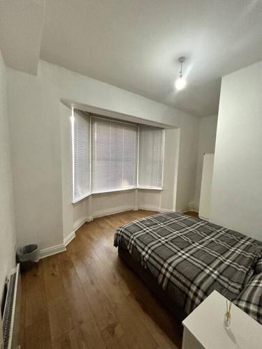 a bedroom with a bed and a large window at Leicester spacious flat with free parking in Leicester