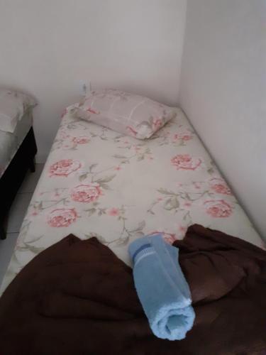 a bedroom with a bed with a flower patterned bedspread at Espaço igor in Aparecida