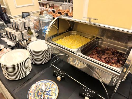 a buffet line with plates of food on a counter at The Regency Sure Hotel Collection by Best Western in Lissone
