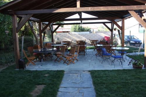 un patio avec des tables et des chaises sous un pavillon dans l'établissement Albergue la Medina de Camponaraya, à Camponaraya