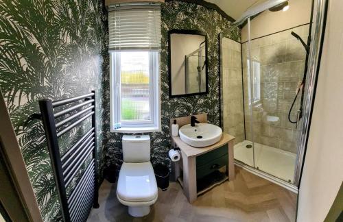 łazienka z toaletą, umywalką i oknem w obiekcie Heather William Luxury Lodge in Woodhall Spa w mieście Woodhall Spa