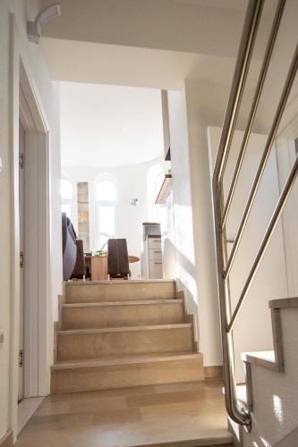 a staircase in a home with white walls and wooden floors at Kula Centar in Trebinje