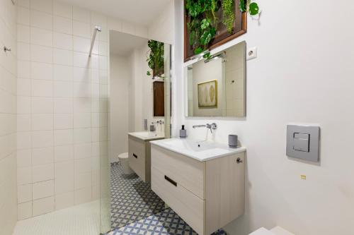 un bagno con due lavandini e una doccia di Cosy Remodeled apartment in the City center a Fundão