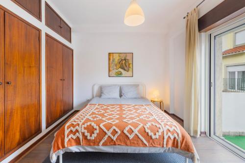 a bedroom with a bed and a large window at Cosy Remodeled apartment in the City center in Fundão