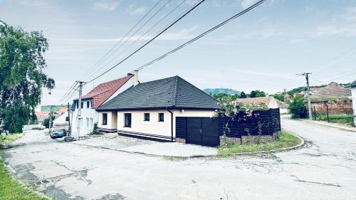 a white house with a black roof on a street at Dům Pálava in Perná
