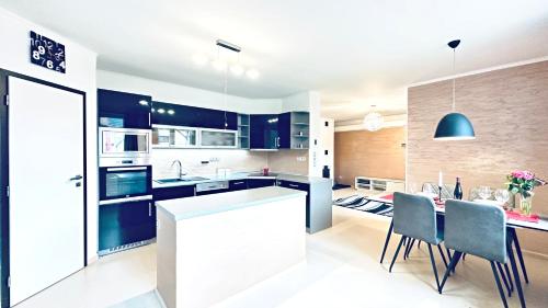 a kitchen with blue cabinets and a table with chairs at Dům Pálava in Perná