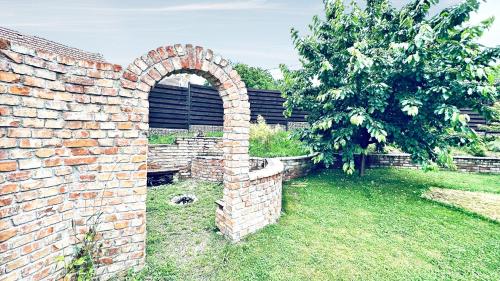 a brick wall with an arch in a yard at Dům Pálava in Perná