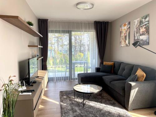 sala de estar con sofá y TV en Open Sea Panorama Residence, en Obzor