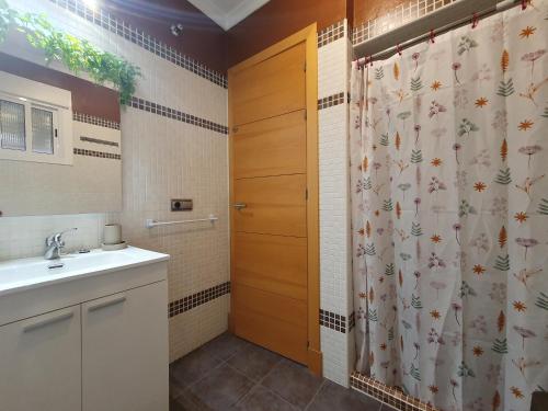 a bathroom with a shower curtain and a sink at La Casa del Bosque in El Bosque