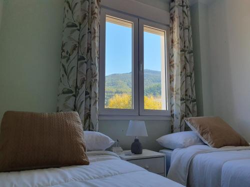 a room with two beds and a window at La Casa del Bosque in El Bosque