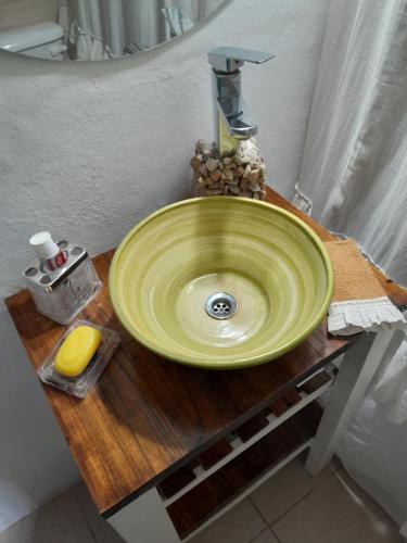 un lavabo verde sobre una mesa de madera en el baño en La casita de Tigre Centro en Tigre