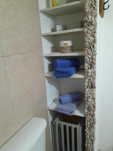 y baño con aseo blanco y toallas azules. en La casita de Tigre Centro en Tigre