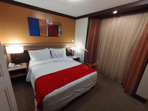 a hotel room with a large bed with a red blanket at Laje de Pedra Mountain VillagePrime in Canela
