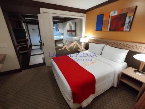 a hotel room with a bed with a red blanket at Laje de Pedra Mountain VillagePrime in Canela