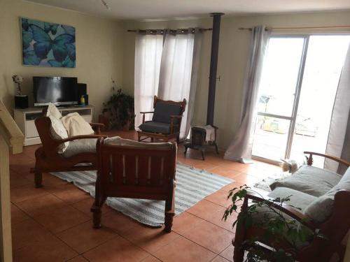 salon z kanapą, krzesłami i telewizorem w obiekcie CASA EN GUANAQUEROS w mieście Coquimbo