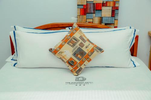 a pillow sitting on top of a bed at Arusha Diplomat Hotel & Conference in Marombosa