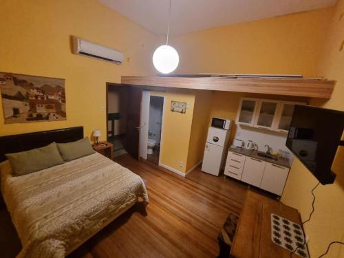 ein Schlafzimmer mit einem Bett und eine kleine Küche in der Unterkunft Posada Santa Rita in Colonia del Sacramento