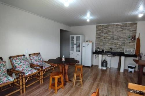 ein Wohnzimmer mit einem Tisch und Stühlen sowie einem Kühlschrank in der Unterkunft Edícula familiar - Ao lado BR277 in Guarapuava