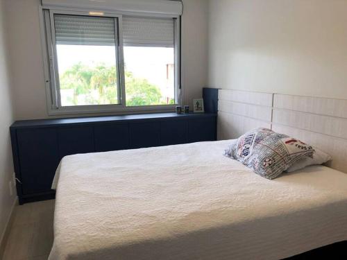 a bedroom with a large bed with a pillow on it at Apartamento vista mar resort in Florianópolis