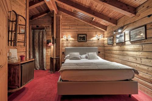 a bedroom with a bed in a room with wooden walls at Chalet BRAGARD in Limone Piemonte