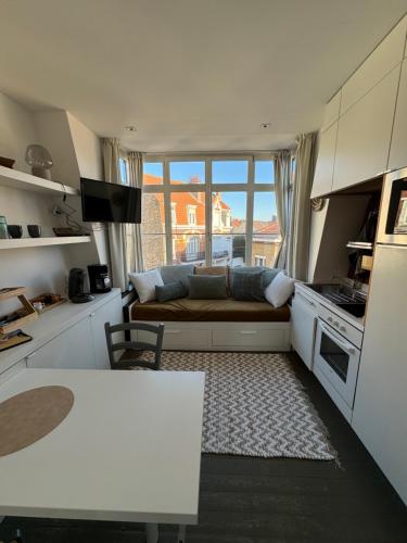 - une cuisine avec un canapé et une table dans une chambre dans l'établissement Maison Belle Rade : L’écoutille, à Dunkerque