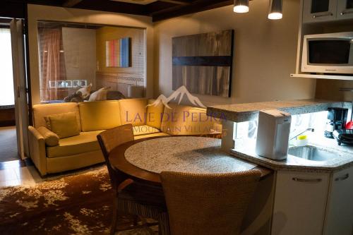 a kitchen and living room with a table and a couch at Laje de Pedra Mountain VillagePrime in Canela