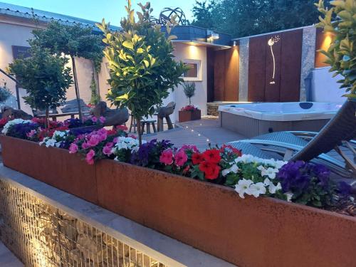 a retaining wall with flowers in a yard at La Renaissance 1&2 high standing guest house in Herve