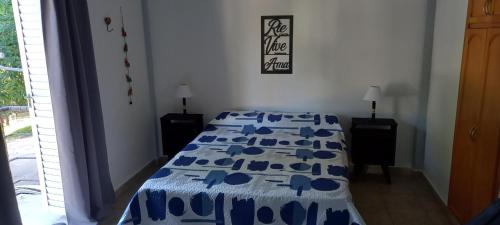 1 dormitorio con 1 cama con edredón azul y blanco en Moreno 40 en Colón