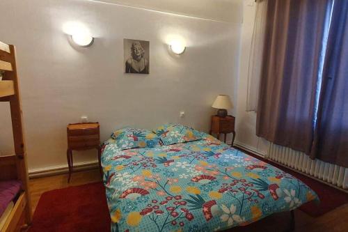 une chambre avec un lit avec une couette colorée dans l'établissement Grand appartement proche Paris, à Montreuil