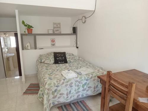 - une petite chambre avec un lit et une table dans l'établissement GUILLOTE APART, à Neuquén
