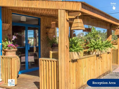 a wooden shop with a bell and plants in it at West Coast Inn's in Boqueron