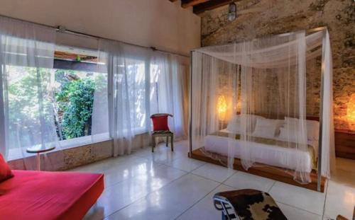 a bedroom with a canopy bed and a large window at Casa de los sueños in Cartagena de Indias