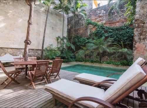 a patio with a table and chairs and a pool at Casa de los sueños in Cartagena de Indias