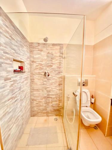 a bathroom with a shower and a toilet at Sophlin home in Ukunda