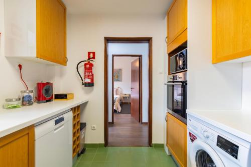 a kitchen with a washer and dryer at Remodeled historical apartment in the City center in Fundão