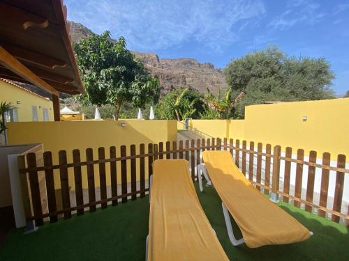 a wooden bench sitting on the side of a fence at SUNNY CARMELITO DELUXE in Mogán
