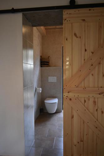 baño con aseo y puerta de madera en Cihloffka Přijeďte vypnout., en Rovensko pod Troskami