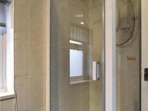 a shower with a glass door in a bathroom at Middle Kellet - Uk46180 in Silecroft