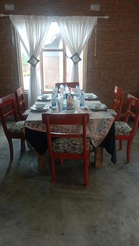 uma mesa de jantar com cadeiras e uma mesa com pratos em dunduzu village lodge em Mzuzu