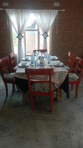 a dining room table with chairs and a table with dishes at dunduzu village lodge in Mzuzu