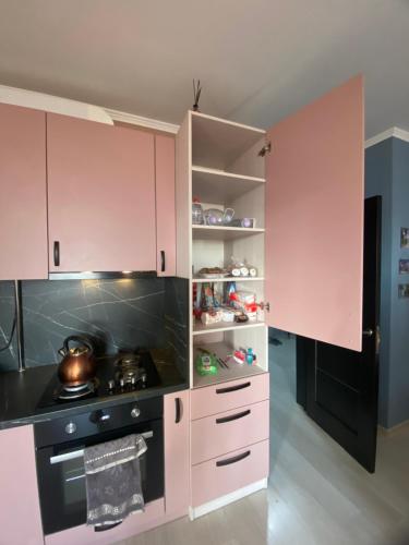a kitchen with pink cabinets and a stove at Moldova Balți center in Bălţi